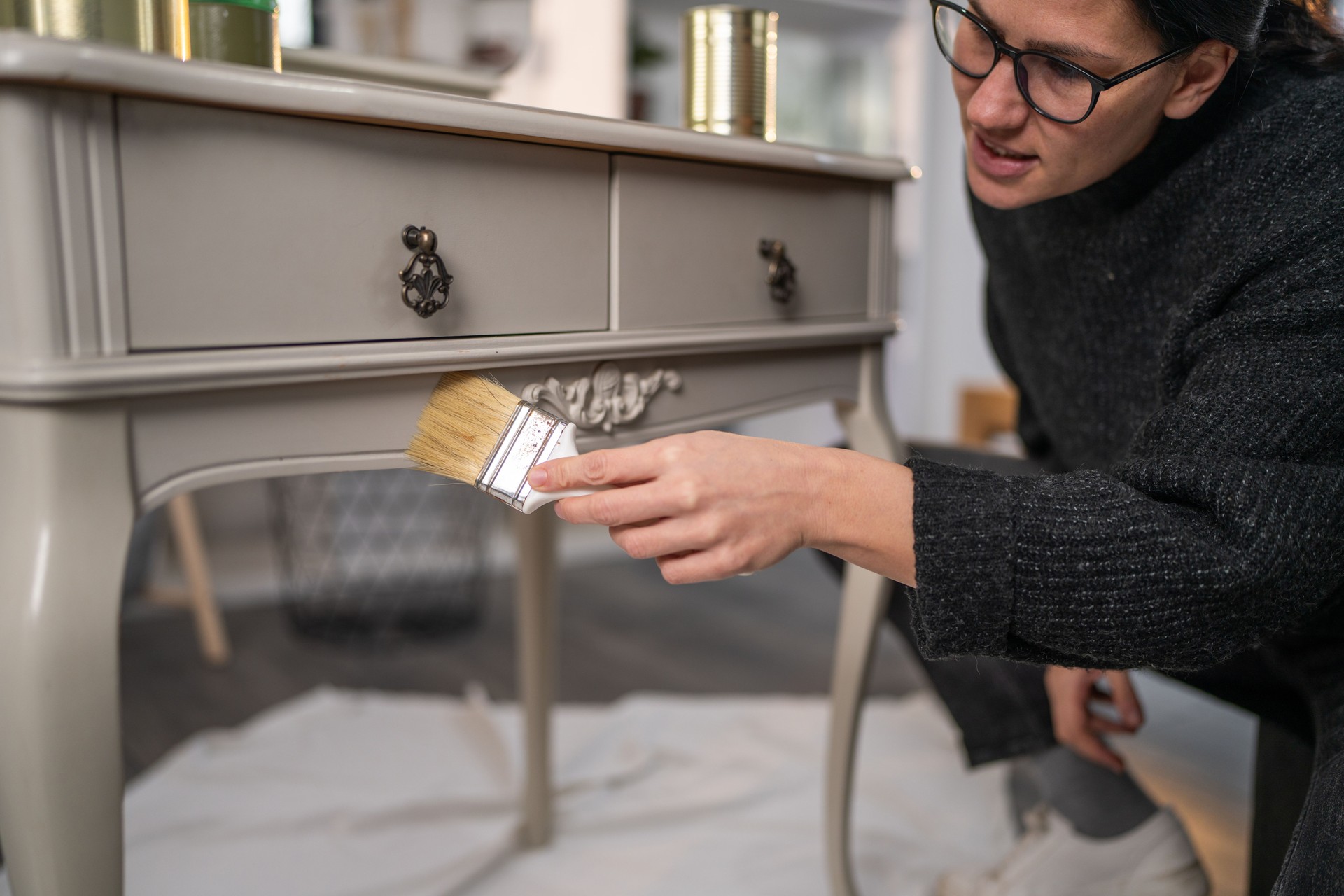 Crafty woman painting vintage dressing table at home